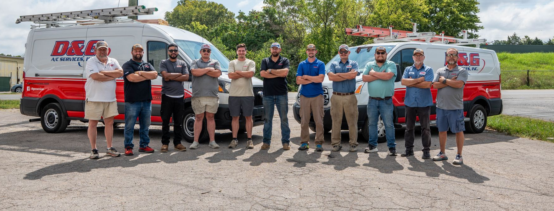 D&G A/C Services team standing with red and white service vans