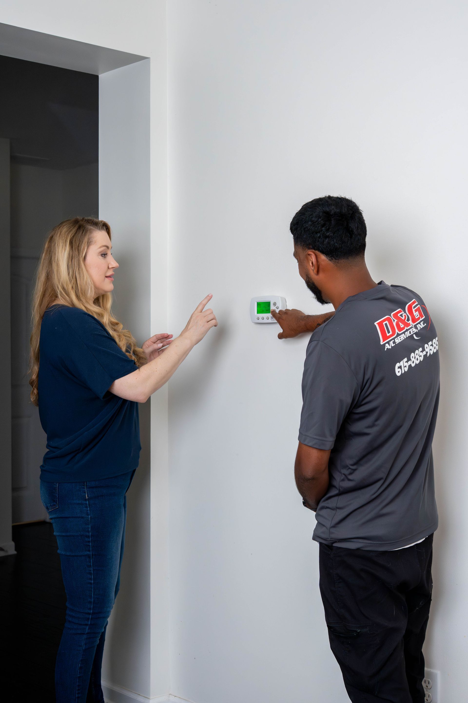 D&G technician reviewing thermostat settings with a homeowner